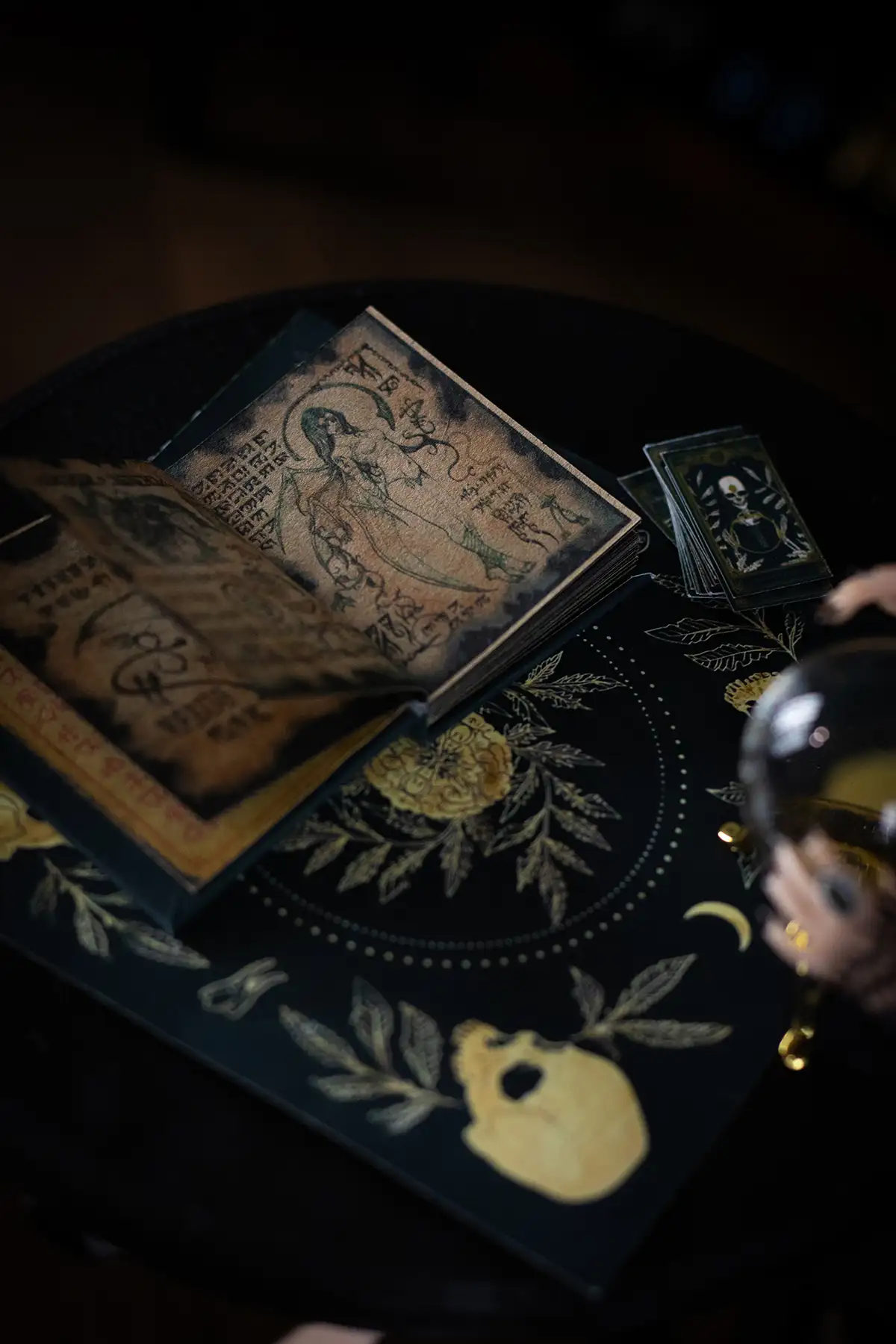 Miniature spellbook and crystal ball on a witch table