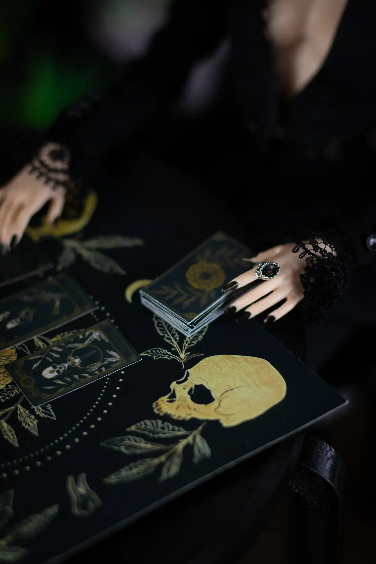 Doll hands resting beside fortune-telling cards